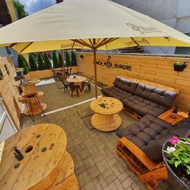 Drevený obklad stien na terase pizzérie a paletové sedenie