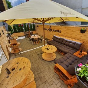 Drevený obklad stien na terase pizzérie a paletové sedenie